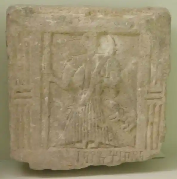 A man wearing a robe holding a staff together with a four-legged animal